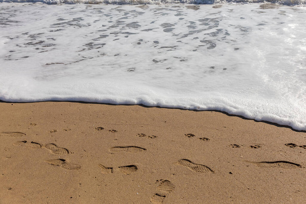 A soft sea wave rolls onto the sand of the beach. Seascape waves on the coast - Photo, image