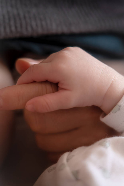 Las manos de los padres sosteniendo los dedos del bebé recién nacido, Cierre la mano de la madre sosteniendo a su bebé recién nacido. Amor cuidado de la salud familiar y médico parte del cuerpo concepto del día del padre bandera panorámica
 - Foto, imagen