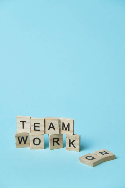 Wooden elements with letter on light blue background spelling word teamwork - Photo, Image