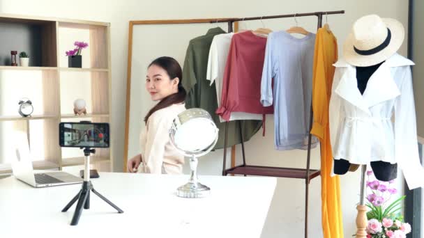 4k wideo Atrakcyjny młody vlogger mody siedzi przed kamerą nagrywania wideo o modzie i odzieży w salonie - Materiał filmowy, wideo