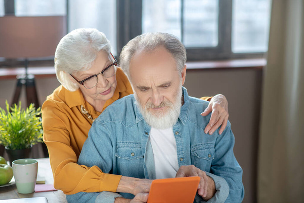 Elderly man and woman learning to use a tablet together - Photo, Image