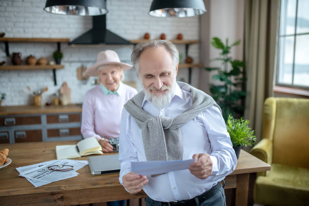 Smiling elderly man reading an important letter - Foto, Imagen