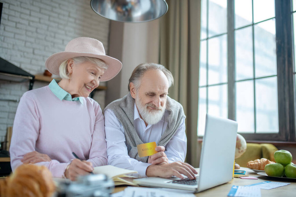 Elderly man and woman using a computer together - Фото, изображение