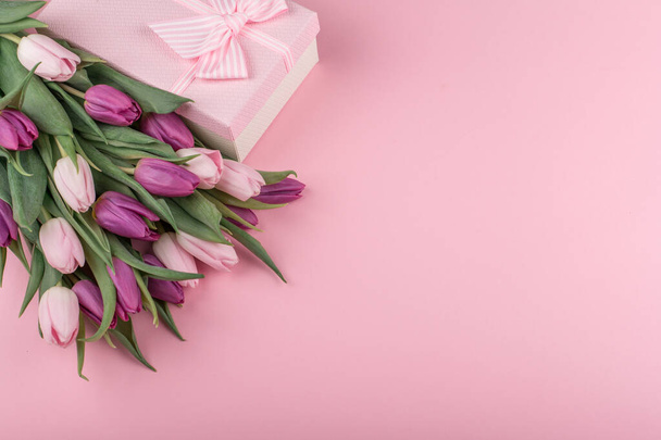 kytici voňavých růžových a fialových tulipánů a dárek pro dámský den na růžovém pozadí. Zdravím vás na Den matek. kopírovat prostor - Fotografie, Obrázek
