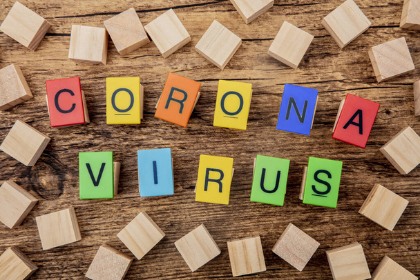 Σύμβολο κορώνα εικόνα ιός με ξύλινα κυβάκια και πολύχρωμα γράμματα - Φωτογραφία, εικόνα