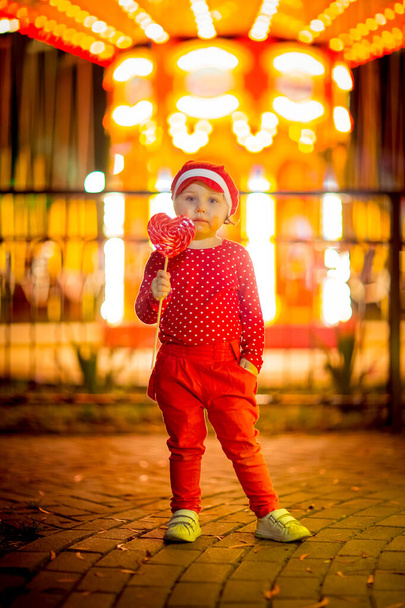 A little, cool girl in red clothes and a cap. - 写真・画像