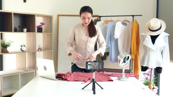 4k video: Çekici genç moda video blogcusu kameranın önünde oturmuş galeride moda ve giysi hakkında video kaydediyor. - Video, Çekim