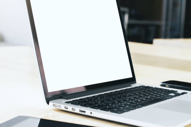 Крупним планом сучасний ноутбук з порожнім екраном на столі в сонячному інтер'єрі, макет. Концепція бізнесу та технологій
 - Фото, зображення
