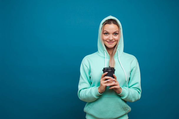 Stylish trendy hipster girl in a blue hoodie with a hood - Fotó, kép