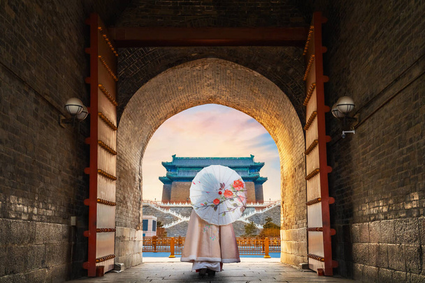 Chińska dziewczyna w tradycyjnej zimowej sukience w Qianmen lub Zhengyangmen Gate w Pekinie, Chiny - Zdjęcie, obraz