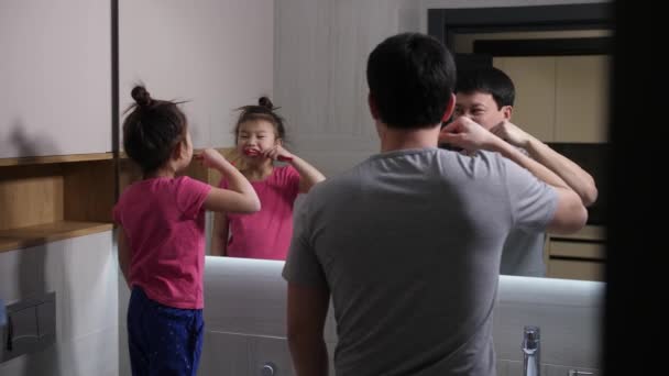 Asijské táta a dcera čištění zubů v koupelně - Záběry, video