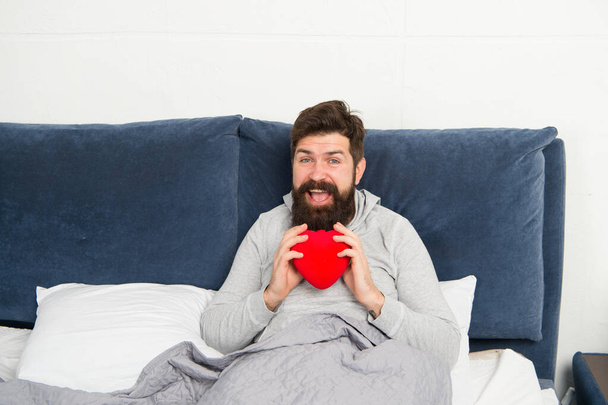 Love and relations. Valentines day. Surprise gift. Holiday celebration. Happy morning. Bearded hipster need some love. Lack of love. Man relaxing in bed. Looking for partner. Take care of heart - Foto, Imagen
