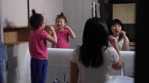 夕方歯磨きのアジアのお母さんと娘 - 映像、動画