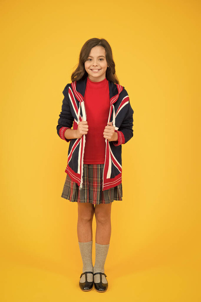 patriotic kid with english flag on jacket. go study to england. learn english language. british school in england. vacation in great britain. travel concept. Union Jack Flag. small girl uniform - Photo, image