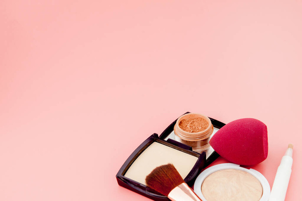 Set of colorful cosmetics on pink wooden table background, base for make-up in the form of a cushion. Copy space. - 写真・画像