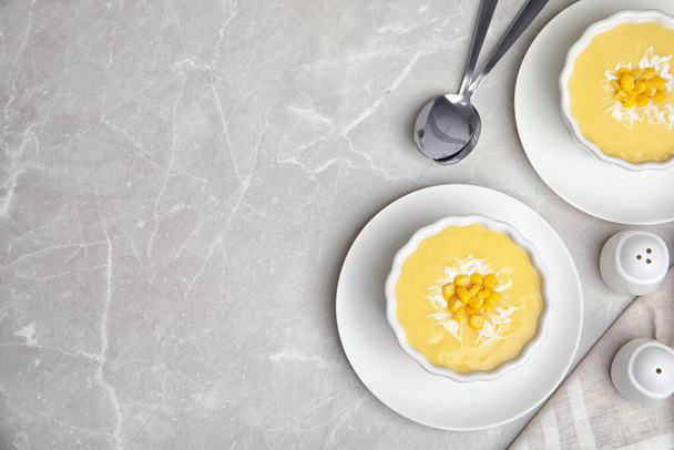 Delicious corn cream soup served on grey marble table, flat lay. Space for text - Фото, изображение