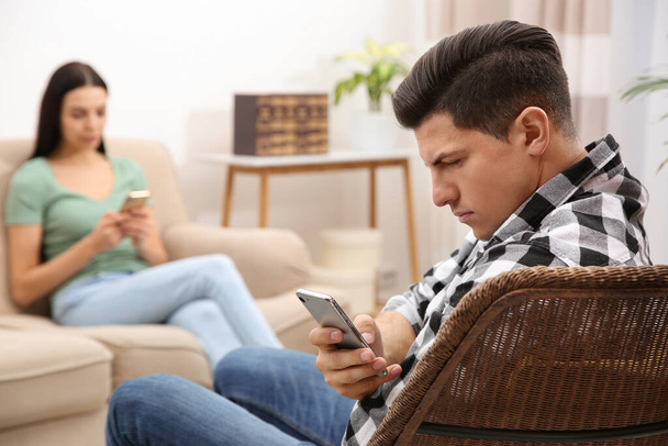 Couple addicted to smartphones ignoring each other at home. Relationship problems - Fotó, kép