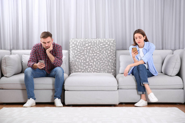 Paar, das süchtig nach Smartphones ist, ignoriert einander zu Hause. Beziehungsprobleme - Foto, Bild