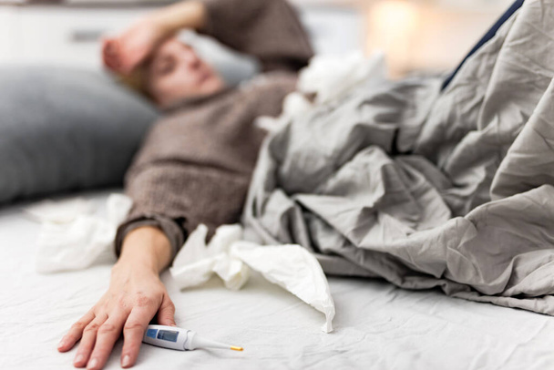 Kobieta chora w łóżku, grypa i infekcje wirusowe, alergia, sezonowe problemy zdrowotne. - Zdjęcie, obraz