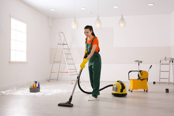 Professional janitor cleaning room with vacuum after renovation - Photo, Image