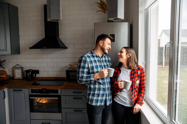 Couple in love in checkered shirts at home - Valokuva, kuva