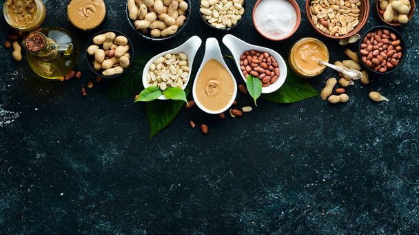 Peanut butter and nuts on a black stone background. Healthy food. Top view. - Foto, Bild