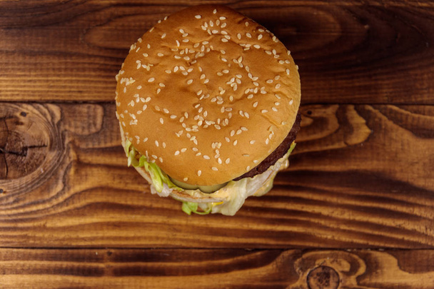 Delicious big hamburger on wooden table. Top view - Foto, afbeelding