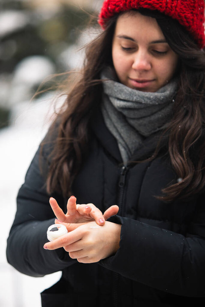 женщина использует сливки в холодную зимнюю погоду. защита кожи. сухое лицо
 - Фото, изображение