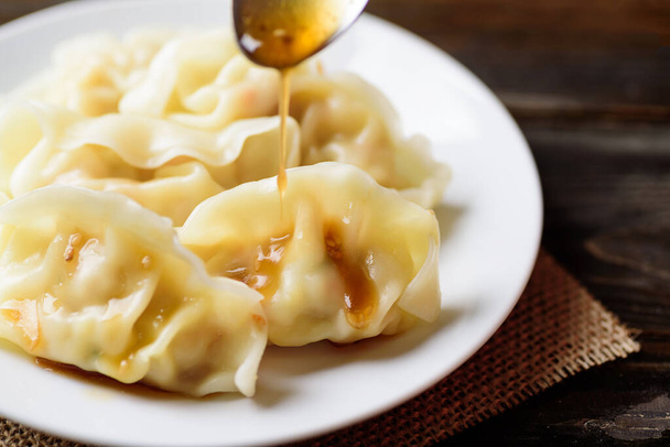 Steamed wonton dumpling stuffed with minced pork and shrimp eating with sesame oil sauce, Asian food - Photo, Image