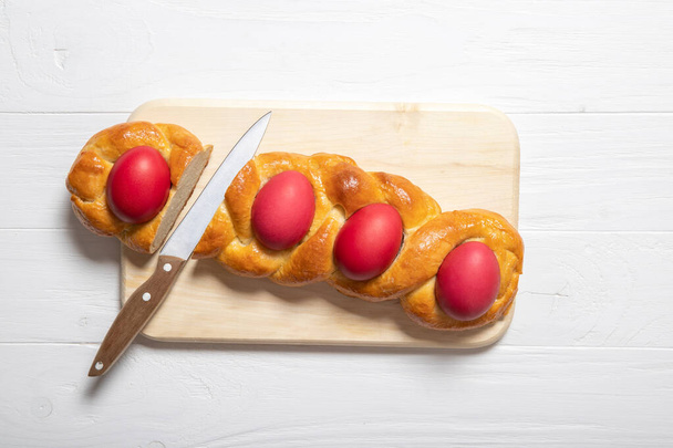 Sabroso pan de Pascua. Pan de Pascua y huevos rojos. Pan de Pascua italiano
 - Foto, Imagen