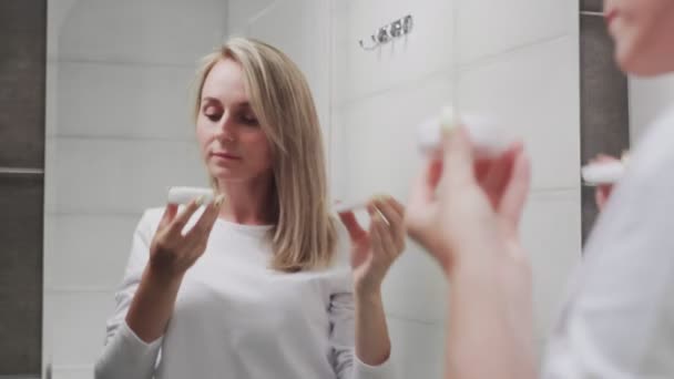 Woman applying cream and looking in mirror enjoy natural beauty and healthy - Materiaali, video