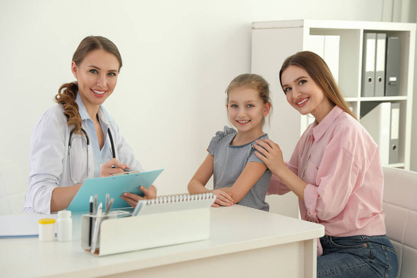 Mother and daughter visiting pediatrician. Doctor working with patient in hospital - Foto, imagen