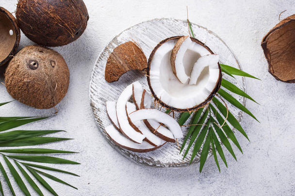 Sliced coconut and palm leaves - Photo, Image