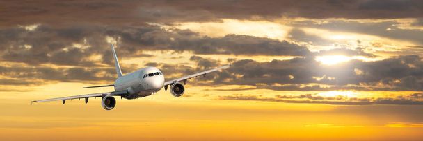 Lentokone. Maisema iso valkoinen matkustaja lentokone lentää keltaisella taivaalla värikäs auringonlasku. Matka. Matkustajalentokone laskeutuu hämärässä. Liikematka. Kaupallinen taso
 - Valokuva, kuva