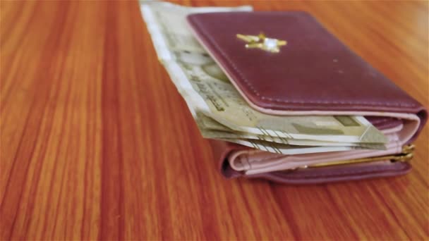 Indian five hundred (500) rupee cash note in brown color wallet leather purse on a wooden table. Business finance economy concept. Side angel view, extreme close up with copy space room for text. - Footage, Video