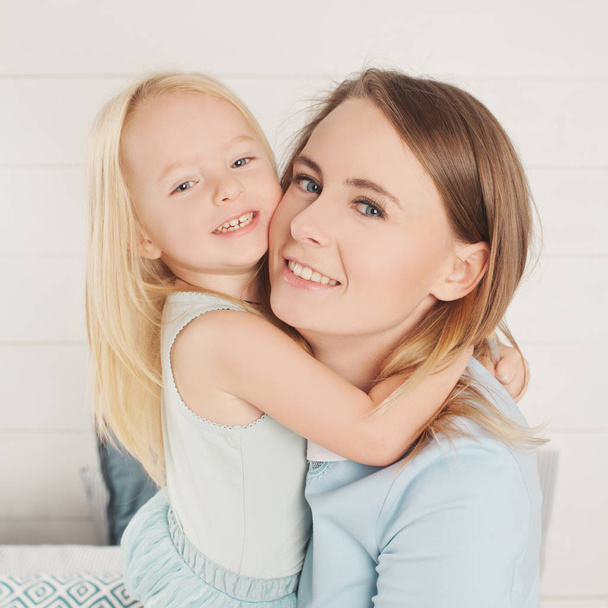 Closeup portrait of cute mother and little daughter cuddling - Photo, Image