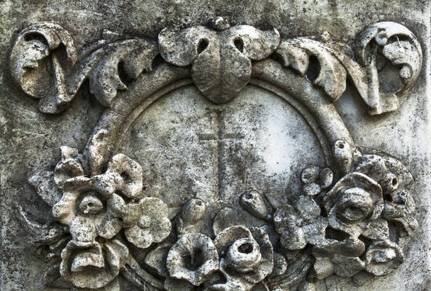 Kříž v květinové ozdobě na starém náhrobku. Zavřít. - Fotografie, Obrázek