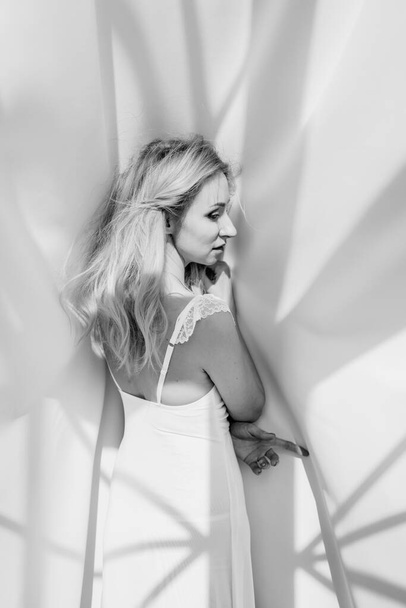 blonde girl in a white dress on a white background - Foto, afbeelding
