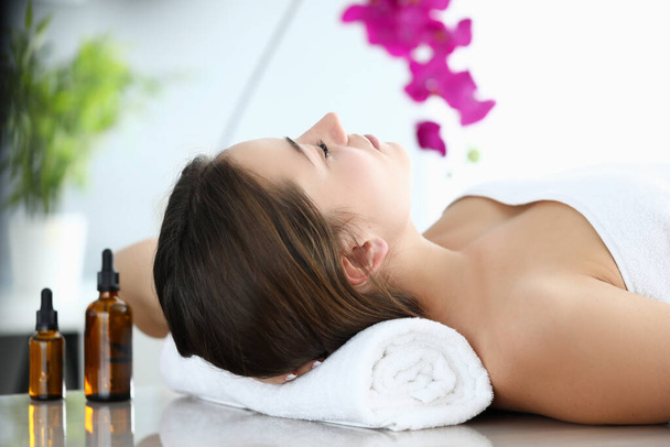 Ragazza si trova in sala massaggi, vicino agli oli aromatici
 - Foto, immagini
