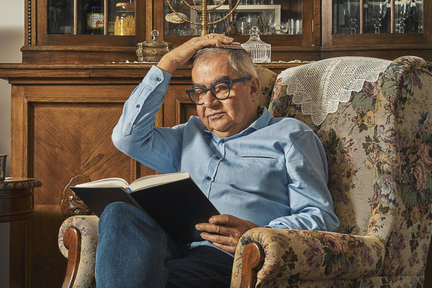 Starszy Żyd czyta książkę w tradycyjnym domu  - Zdjęcie, obraz