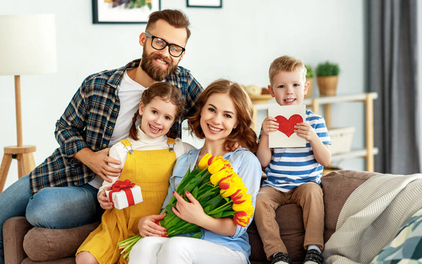 glücklicher Muttertag! Vater und Kinder gratulieren Mutter zum Urlaub und schenken Blumen - Foto, Bild