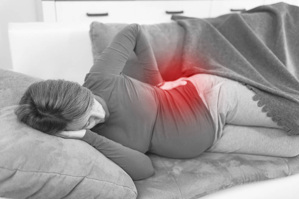 Беременная уставшая измученная женщина с проблемами желудка дома на диване, болеющая
. - Фото, изображение