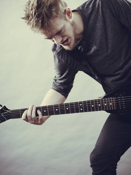 Man being passionate about his music hobby, playing electric guitar emotionally. - Valokuva, kuva