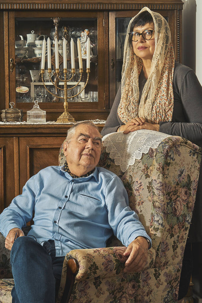 Pareja mayor judía posa en sillón en casa tradicional
  - Foto, Imagen