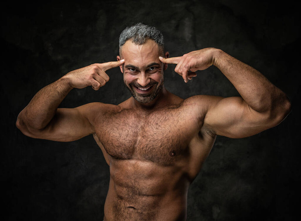 adulto caucasiano musculoso fisiculturista mostrando seus músculos e olhando para a câmera, olhar retrato
 - Foto, Imagem