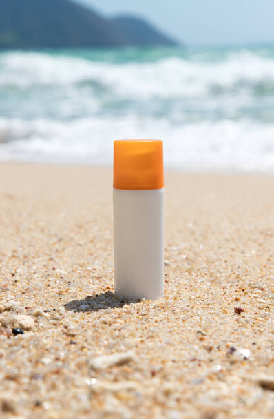 海水による砂浜の日焼け止め化粧水のボトル。健康スキンケア太陽の保護の概念。天然成分の化粧品. - 写真・画像