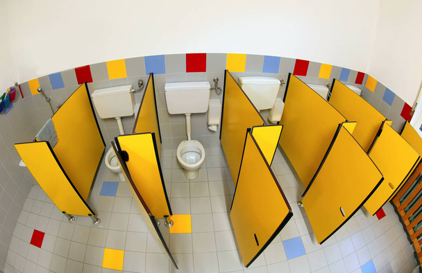 Gelbe Türen im Badezimmer eines Kindergartens ohne Kinder - Foto, Bild