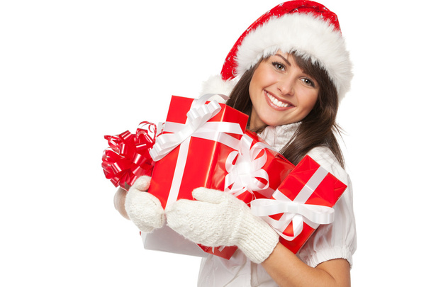 Woman holding gifts wearing red Santa hat - Zdjęcie, obraz
