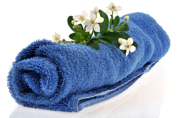 Μπλε πετσέτα μπάνιου με πορτοκαλί λουλούδια close-up σε λευκό φόντο - Φωτογραφία, εικόνα