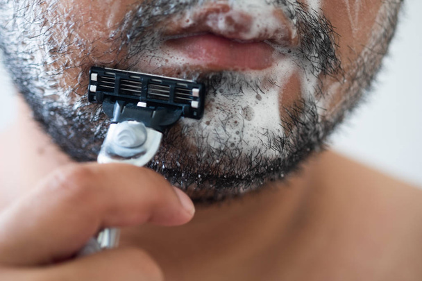 close-up van man scheren met een scheermes - Foto, afbeelding